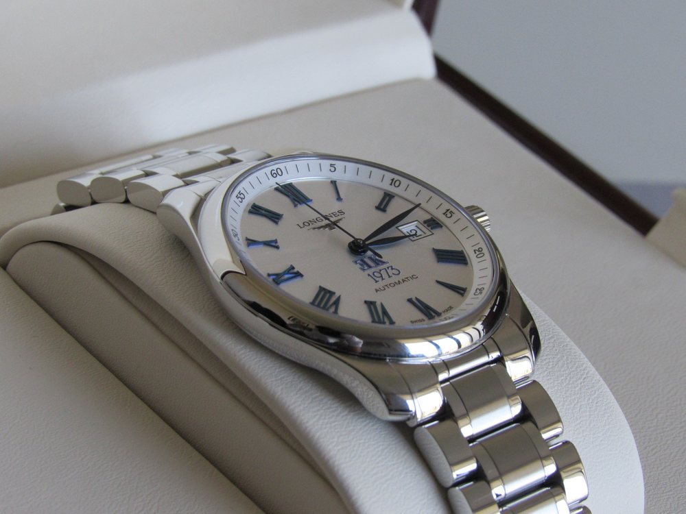 Vista lateral del reloj, con el perfil de la caja de acero y el brazalete.