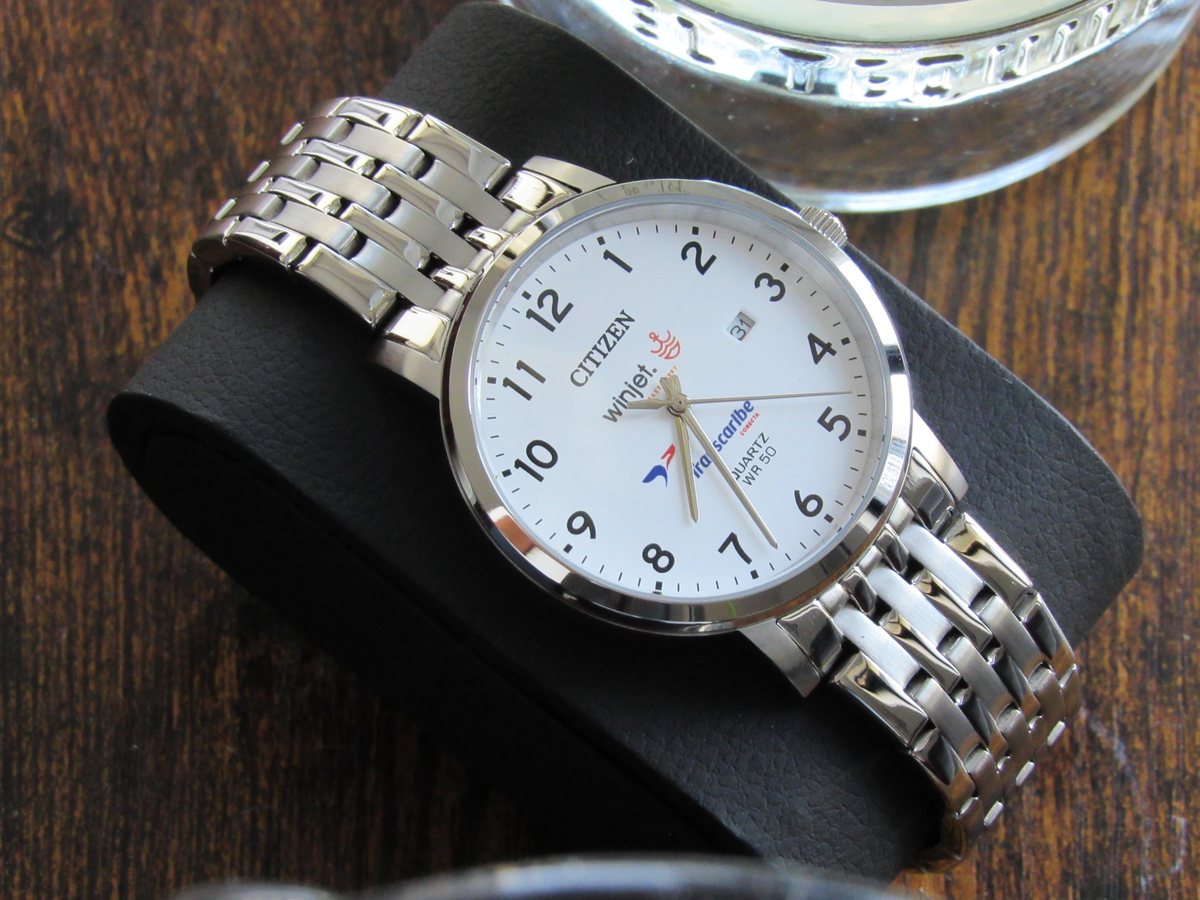El reloj Citizen personalizado apoyado sobre un cojín de piel negra, con la carátula de frente.